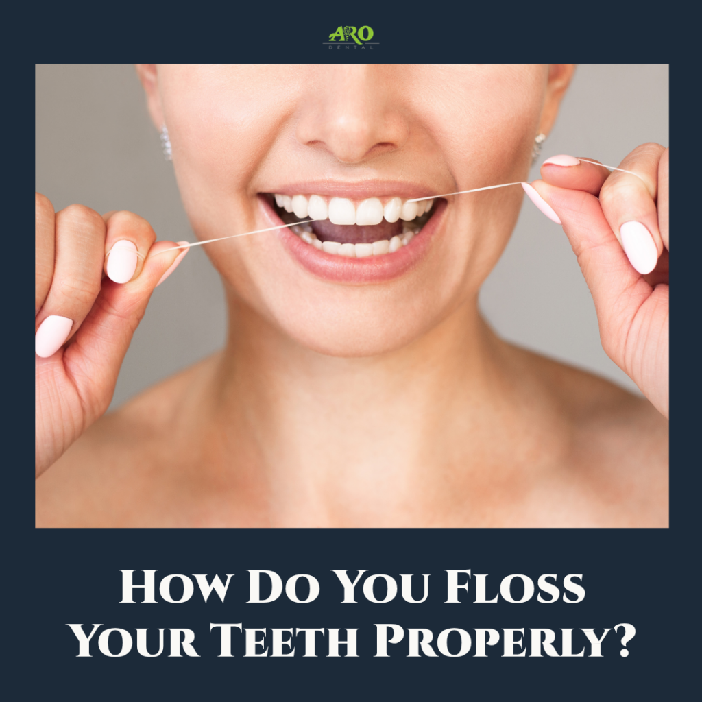 Close-up of a person correctly wrapping dental floss around their index fingers to clean between their teeth.